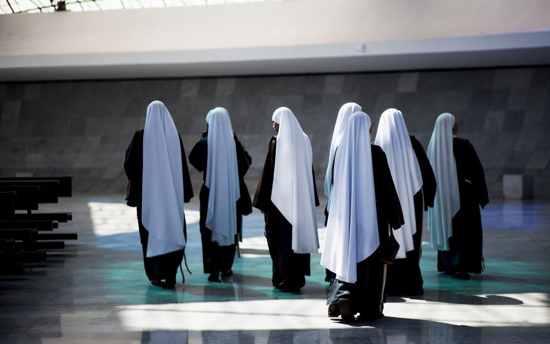 Nuns with long white veils walking away