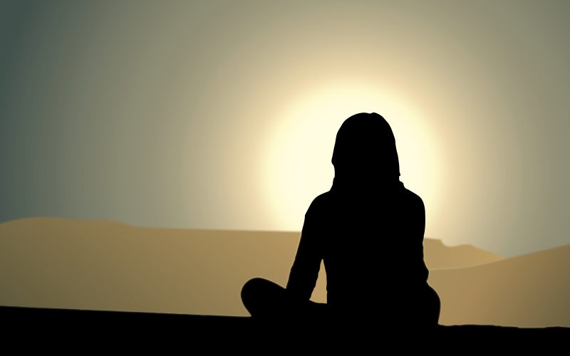 woman sitting in front of sunset